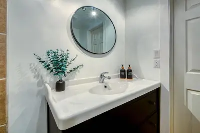 a bathroom with a white sink and a mirror at Backyard Oasis Hot Tub, BBQ, Outdoor Bar in Invermere