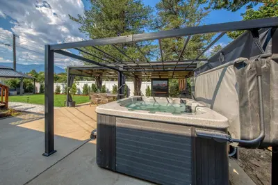 a hot tub in a backyard with a gazebo at Backyard Oasis Hot Tub, BBQ, Outdoor Bar in Invermere
