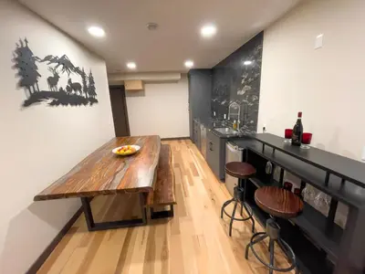 a kitchen with a wooden table and a counter at Romantic Luxury Retreat with Private Sauna & Spa, Pet Friendly, Elkside Hideout B&B in Canmore
