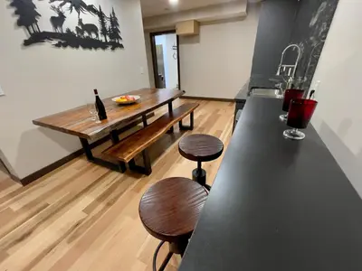 a kitchen with a table and two stools and a bench at Romantic Luxury Retreat with Private Sauna & Spa, Pet Friendly, Elkside Hideout B&B in Canmore