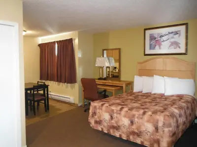 a hotel room with a bed and a desk at Tumbler Ridge Inn in Tumbler Ridge