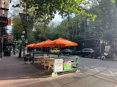 a group of tables with umbrellas on a city street at Hidden Gem: Historical Gastown in Vancouver