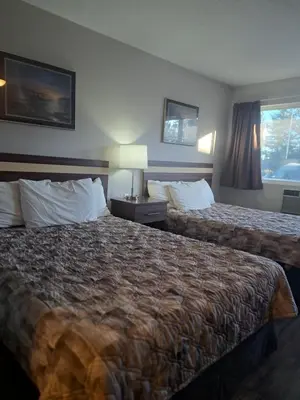 a hotel room with two beds and a window at Bon Voyage Inn in Prince George