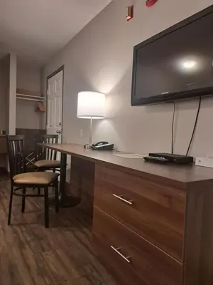 a hotel room with a desk with a flat screen tv at Bon Voyage Inn in Prince George