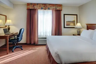 a hotel room with a bed and a desk and a window at Coast Grimshaw Hotel & Suites in Grimshaw