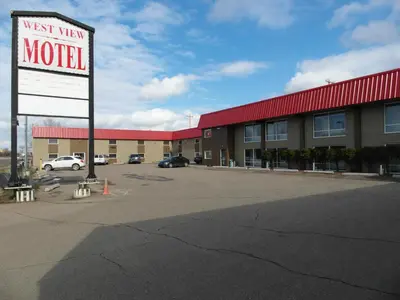a motel sign in front of a parking lot at West View Motel in Hanna