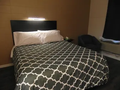 a bedroom with a bed with a black and white comforter at West View Motel in Hanna