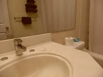 a bathroom with a sink and a toilet and a mirror at West View Motel in Hanna