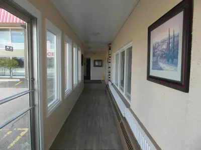 a hallway of a building with windows and a picture on the wall at West View Motel in Hanna