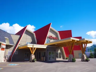 a building with red roofs with a parking lot at The Kanata by BCMInns Blairmore in Blairmore