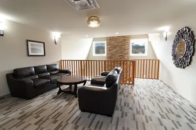 a living room with two couches and a table at The Kanata by BCMInns Blairmore in Blairmore