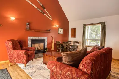 a living room with orange walls and a fireplace at Timbers Resort in Fairmont Hot Springs