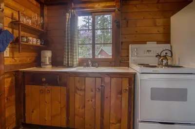 a kitchen with a sink and a stove and a window at Timbers Resort in Fairmont Hot Springs