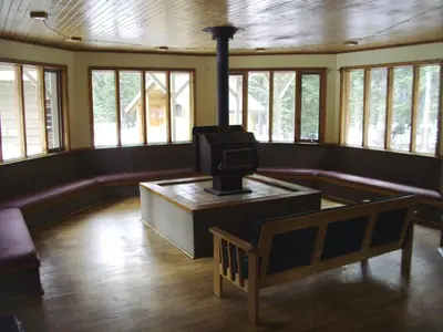 a living room with a stove in the middle of it at HI Mosquito Creek - Wilderness Hostel in Lake Louise