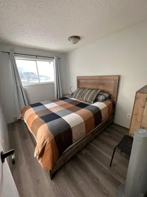 a bedroom with a bed in a room with a window at Cozy Beach 2 bedroom apartment in Invermere