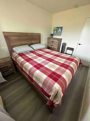 a bedroom with a bed with a red and white blanket at Cozy Beach 2 bedroom apartment in Invermere