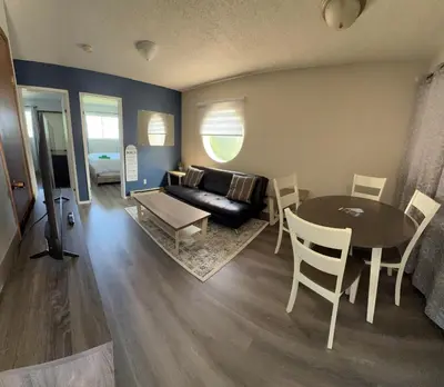 a living room with a couch and a table and chairs at Cozy Beach 2 bedroom apartment in Invermere
