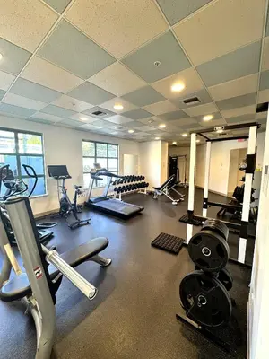 a gym with several treadmills and machines in it at Stunning ocean (sound of waves) in Vancouver