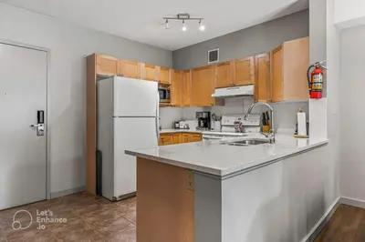 a kitchen with a white refrigerator and wooden cabinets at Rocky Mountain Getaway with Outdoor Heated Pool, 3 Hot Tubs, Gym, BBQ, Garage & 24 hour Reception near Banff in Canmore