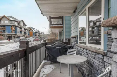 a table and chairs on the balcony of a house at Rocky Mountain Getaway with Outdoor Heated Pool, 3 Hot Tubs, Gym, BBQ, Garage & 24 hour Reception near Banff in Canmore