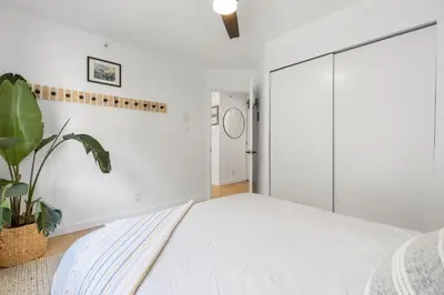 a white bedroom with a bed and a plant at Powderview 12 by Whistler Premier in Whistler