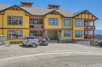 a large yellow house with a car parked in front of it at The Crescent 201 by Okanagan Premier in Big White