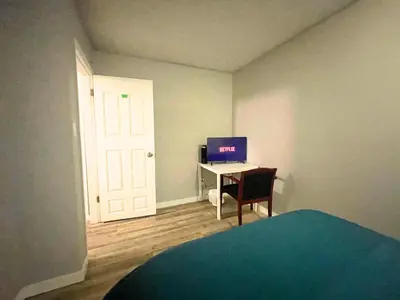 a bedroom with a desk with a computer on it at Flowealth Suites - Private Rooms Near West Edmonton Mall in Edmonton
