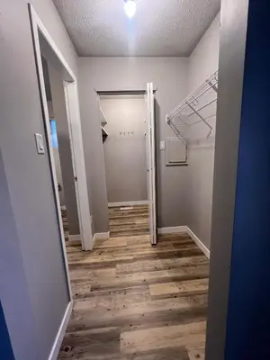 an empty room with a hallway with a closet at Flowealth Suites - Private Rooms Near West Edmonton Mall in Edmonton