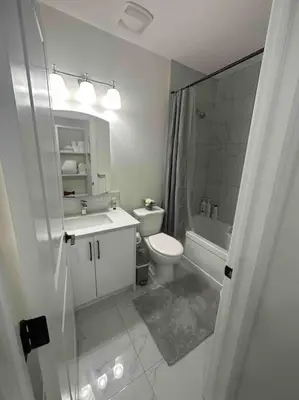 a white bathroom with a toilet and a sink at Award winning boho paradise sunlit modern suite in Calgary
