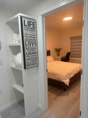 a room with a bedroom with a bed and a sign at Award winning boho paradise sunlit modern suite in Calgary
