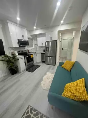 a living room with a blue couch and a kitchen at Award winning boho paradise sunlit modern suite in Calgary