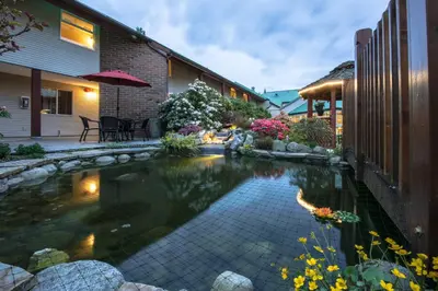 a garden with a pond in the middle of a yard at Gibsons Garden Hotel in Gibsons