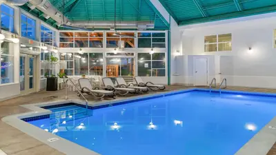 a pool in a building with chairs around it at Gibsons Garden Hotel in Gibsons
