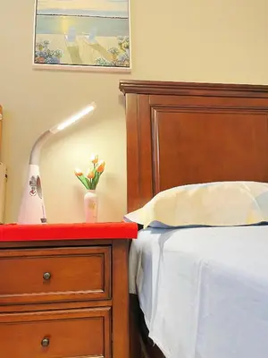 a bedroom with a bed and a dresser with a lamp at Derbyshire House in Coquitlam