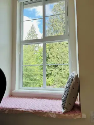a window sill with a pillow in front of it at Derbyshire House in Coquitlam