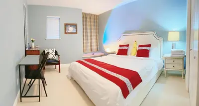 a bedroom with a bed and a desk and a chair at Derbyshire House in Coquitlam