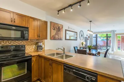 a kitchen with a sink and a stove top oven at Resort Style Living with Private Lawn and Patio in Kelowna