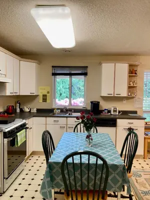 a kitchen with a table with a blue table cloth on it at Red Robe B&B in Nanaimo