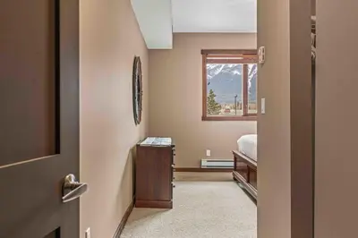 a bedroom with a bed and a window at Best Views of Canmore - 2Bed 2Bath in Canmore