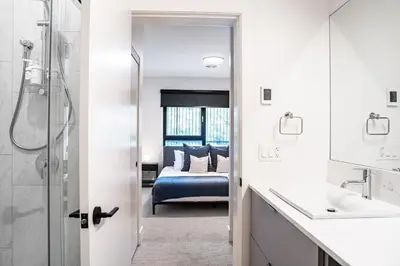 a bathroom with a shower and a bedroom with a bed at Serenity Now by Revelstoke Vacations in Revelstoke
