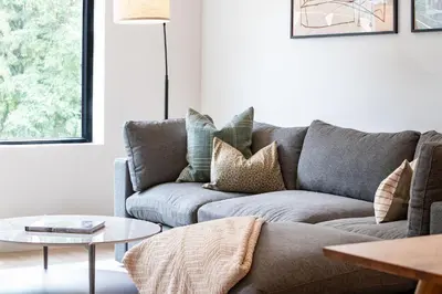 a living room with a gray couch and a table at Serenity Now by Revelstoke Vacations in Revelstoke