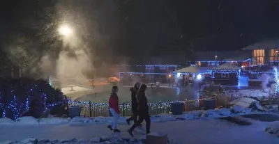 two people walking in the snow at night at Mountain View Vacation Villa Main Floor Unit, No Stairs in Fairmont Hot Springs