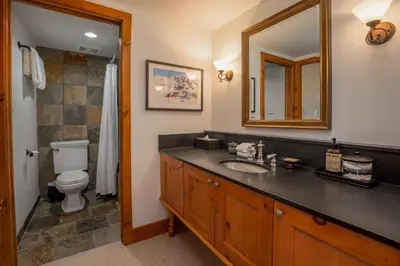 a bathroom with a sink and a toilet and a mirror at 3BR in Snowberry, King Bed, Wood Burning Fireplace, Large Kitchen, Near Gondola in Whistler