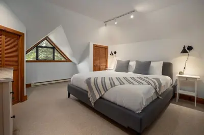 a bedroom with a large bed and a window at 3BR in Snowberry, King Bed, Wood Burning Fireplace, Large Kitchen, Near Gondola in Whistler