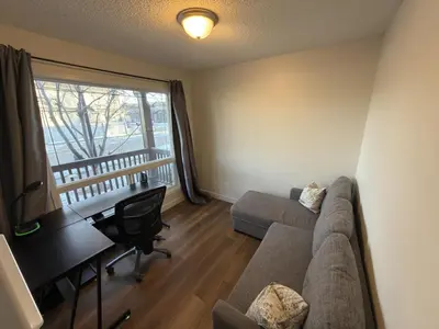 a living room with a couch and a desk at Spacious & Private Retreat near West Edmonton Mall in Edmonton