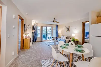 a kitchen and living room with a table and chairs at Lux 2BR/3BD Suite/Mountain View! in Canmore