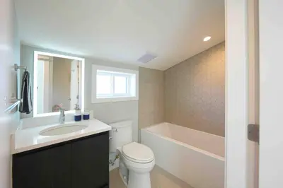 a bathroom with a toilet and a sink and a tub at Four bedrooms New Lovely Duplex -1626 in Vancouver