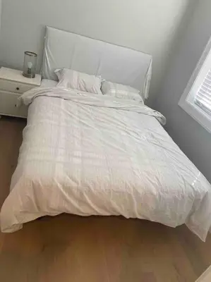 a bed with a white comforter in a bedroom at Four bedrooms New Lovely Duplex -1626 in Vancouver