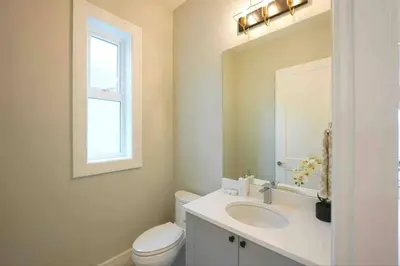 a bathroom with a sink and a toilet and a mirror at Four bedrooms New Lovely Duplex House-1628 in Vancouver