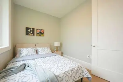a bedroom with a large bed and a window at Four bedrooms New Lovely Duplex House-1628 in Vancouver